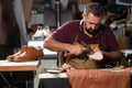 Cobbler at work repairing a leather shoe in a busy workshop Royalty Free Stock Photo