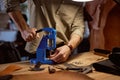 skilled craftsman presses the lever on the press machine in the workshop