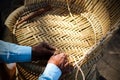 Skilled craftsman working manually a detailed bamboo wood armchair with his fingers and tools Royalty Free Stock Photo