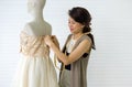 A skilled dressmaker fitting a dress on a mannequin, exhibiting utmost care and detail