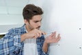 Skilled electrician preparing holes before installing appliance