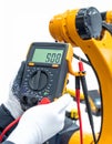 Technician Diagnosing Industrial Robot with Multimeter Royalty Free Stock Photo