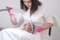 skilled esthetician performs facial treatments, using lamp to see skin problems at aesthetic clinic Royalty Free Stock Photo