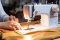 A skilled female tailors hands control a sewing machines needle with precision