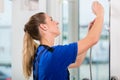 Skilled female worker checking a showerhead in a modern sanitary ware shop