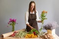 Skilled floral employee. Delicate bloom arrangements. Smiling woman florist creating beautiful bouquet at workplace in flower shop Royalty Free Stock Photo