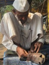 Skilled hands using needal & working on roadside shoe repairer in Kalyan