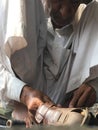 Skilled hands using needal & working on roadside shoe repairer in Kalyan