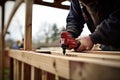 Skilled handyman using power drill for precise wood drilling in home improvement project Royalty Free Stock Photo