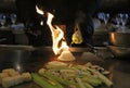 Skilled japanese cook cooking at hibachi grill, tasteful asian food. Fried rice, vegetables, and noodles.