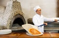 Skilled man chef preparing pizza in restaurant Royalty Free Stock Photo