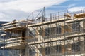 Skilled man standing on scaffolding near incomplete building Royalty Free Stock Photo