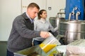 Man and woman inspecting oil decanting