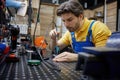 Skilled man worker is working on soldering iron in a workshop Royalty Free Stock Photo