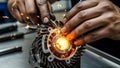 Close up of mechanic hands precision welding a metal engine component creating bright orange sparks in workshop Royalty Free Stock Photo