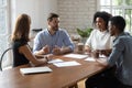 Skilled mixed race colleagues discussing project indoors. Royalty Free Stock Photo