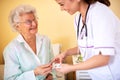 Skilled nursing facility doctor explaining to senior woman occupant which medications she should be taking