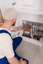 Plumber inspecting heating system pipelines in apartment's technical room Royalty Free Stock Photo