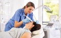 Female aesthetician performing radiofrequency facial skin tightening procedure on mature woman Royalty Free Stock Photo