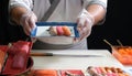 A skilled sushi chef proudly presenting a beautifully arranged plate of delicious sushi, demonstrating the artistry and precision