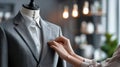 Tailor Adjusting a Grey Suit on a Mannequin in a Stylish Workshop During Daylight Hours Royalty Free Stock Photo