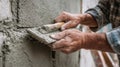 Skilled tradesman applying cement to wall with trowel in construction site environment Royalty Free Stock Photo