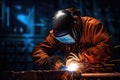 A skilled welder is seen working on a piece of metal inside a bustling factory, Welder in welding helmet working on metal with Royalty Free Stock Photo