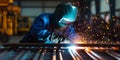 Skilled Welder works in a fabrication shop welding metal work - They are wearing protective Fire resistant clothing