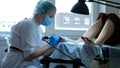 Skilled woman in blue mask performs professional pedicure