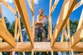 Skilled Worker Constructs Wooden Framework Under Blue Sky at Outdoor Construction Site Royalty Free Stock Photo