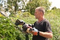 Skilled workman cutting hedges