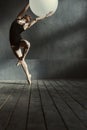 Skilled young gymnast performing using the white balloon