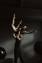 Skilled young gymnasts dancing together in the black colored studio