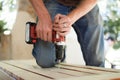 Skilled young male worker is using power screwdriver drilling during construction wooden bench, do it yourself Royalty Free Stock Photo