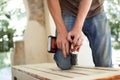 Skilled young male worker is using power screwdriver drilling during construction wooden bench, do it yourself Royalty Free Stock Photo