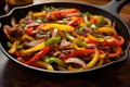 Skillet Filled With Meat, Peppers and Onions, Delicious One-Pan Dish for a Flavorful Meal, Sizzling fajitas with colorful bell