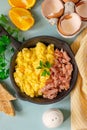 Skillet of scrambled eggs with bacon lardons for breakfast Royalty Free Stock Photo