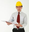 A skillful asian architect with neat and tidy shirt with protective helmet while holding a blueprint ,looking carefully on details Royalty Free Stock Photo