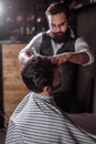 Skillful barber. Young man getting an old-fashioned shave with s