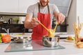 Skillful chef taking noodle from pot