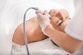 Skillful cosmetologist undergoing ultrasound anti-aging procedure