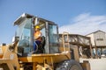 Multiracial construction worker using heavy machinery in plant Royalty Free Stock Photo