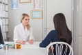 Skillful female doctor is consulting her patient. Young woman doctor is talking to her patient