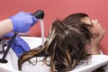 Skillful hairdresser washes hair before styling, long haired teen girl in hair salon