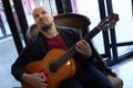 Skillful male guitarist performs with emotion in indoor concert