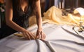 Skillful seamstress in atelier carefully trims fabric using sharp scissors