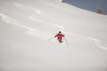 Skillful skier skiing downhill in deep snow