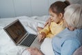 Smart child exploring medical solutions for her grandma online