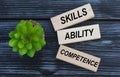 SKILLS, ABILITY, COMPETENCE , words on wooden blocks on a beautiful dark background with cactus