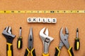 SKILLS word written on wood blocks. Various tools on cork background. business concept Royalty Free Stock Photo